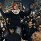 An Egyptian woman celebrates with other people at Tahrir square, in Cairo after President Hosni...