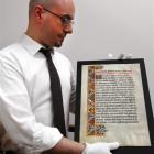 Anthony Tedeschi examines a page from a 500-year-old Spanish manuscript at the Dunedin Public...