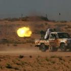Anti-Gaddafi fighters use an anti-aircraft gun as they return fire at pro-Gaddafi forces, about...
