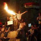 Anti-Mursi protesters light flares as they chant slogans during a second day of demonstrations in...