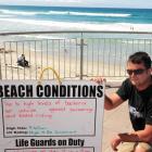 Antony Mason with the St Clair Surf Life Saving Club's sign warning against swimming at the beach...