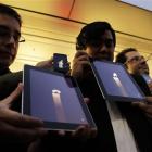 Apple fans hold iPhones and iPads displaying candle graphics during a candle-light vigil to pay...
