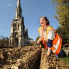 Archaeologist Sheryl McPherson inspects a trench being dug to carry cables for a new security and...