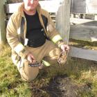 Arrowtown Fire Chief Garry Hall holds two pieces of earth, which were turned into glass when an...