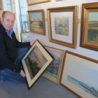 Arrowtown Gallery manager Simon Beadle admires newly released original artworks by  deceased...