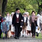 Arrowtown School principal Robin Harris leads pupils - dressed in period costume - to the school...