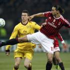 Arsenal's Laurent Koscielny (L) and AC Milan's Zlatan Ibrahimovic fight for the ball during their...