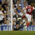 Arsenal's Robin van Persie, right, scores past Tottenham goalkeeper Heurelho Gomes and Michael...