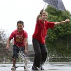 Arthur Street School pupils  Jadin Cummings (left, 7) and Bailey Owens (11) play in the rain...
