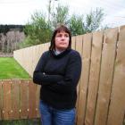 Port Chalmers resident Kathryn Dawe is unhappy about a 40m-long wooden fence which has been built...