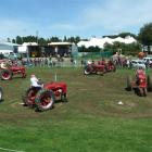 Four pairs of vintage Farmall H tractors perform a "tractor dance" at the 98th West Otago A and P...