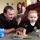 Barnardos home-based child carer Scott McInnes (left) plays with his son Regan (10 months) as...