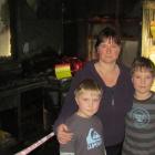 Benjamin Brosnan (9), Belinda Brosnan, and Joel Brosnan (10) yesterday inspected a house ruined...