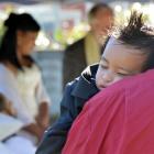 Benjamin Paulo sleeps on a guest's shoulder during the marriage ceremony of his parents, Jesse...