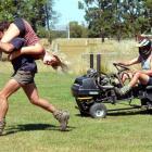 Bevan Wilson carries Hanna-Kaisa Ilhalainey and Kent Tisdall races a modified lawnmower in...