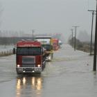 Big trucks negotiate flooding on State Highway 1 north of Oamaru in late May. Photo by Stephen...