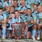 Blues players pose with the trophy after game three of the State of Origin series. (Photo by Mark...