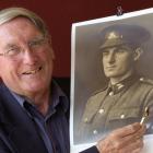 Brian Robertson holds the bullet that saved his father Harry's (pictured) life on the battlefield...