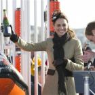 Britain's Prince William applauds, as Kate Middleton holds uo a champagne bottle after naming a...