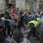 British riot police officers clash with demonstrators against the coalition government's spending...