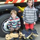 Brothers Zac (3) and Ben (7) McAuliffe try on a pair of firefighter's boots for size at the...