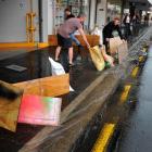 Cafe LOL owner Paul Martin and Wall Street manager Regan Bennett put out sandbags and boards in...