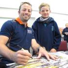 Caleb Dickson (9) watches Klark Quinn sign posters at Goldfields Primary School. Photo by Sarah...