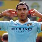 Carlos Tevez of Manchester City celebrates, gesturing towards Norwich City fans, after scoring...