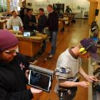 Carpentry student John Broomhall (front left) holds an iPad which has a practical power-tool...