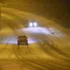 Cars move along Taieri Rd, Dunedin, about 10pm yesterday, as snow continues to fall. Photo by...