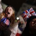 Caryll Foster, of Kingston on Thames, England, left, cheers with other royal enthusiasts as they...