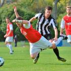 Caversham's Ant Hancock  falls in the challenge of Northern's Mike Scott during a Footballsouth...
