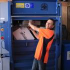 Central Otago WasteBusters employee Franky Harris loads cardboard into a new baling machine that...