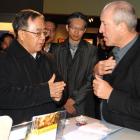 Chinese Communist Party chief of Guangdong province, Hu Chunhua, is presented with a gift of...