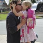 Christchurch earthquake evacuee Michael Gee gives his daughter Willow a hug and a kiss before she...