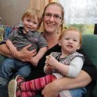 Chrystal O'Malley holds twins Chase, left, and Amelia Gillespie (13 months), at home in...