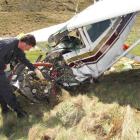 Civil Aviation Authority safety investigator Colin Grounsell  examines  the wreckage of the...