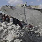 Civil defence members and civilians search for survivors under the rubble of a site hit by what...