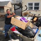 Cliff Seque, of Dunedin, fills a trailer with rubbish removed from one student flat in...