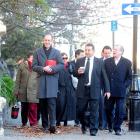 Clutching what appears to be a red lunchbox, David Bain walks to the High Court at Christchurch...