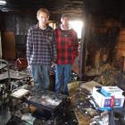 Colin Melvin (left) and a friend, Sid Winterburn, stand in the gutted lounge of Mr Melvin's...