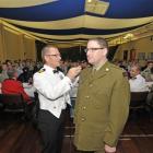 Commander Glen Stokes, of the Royal New Zealand Navy, attaches  ''pips'' to the uniform of  Paul...