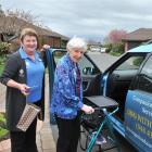 Companion service owner Lyn Hippolite (left) helps client Iris Finlayson-Bartlett back to her...