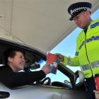 Constable Dave Bullot hands an ice scraper and free coffee to motorist Rachel Ovens at BP Connect...