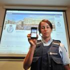 Constable Kristyn Adamson displays a smartphone and large screengrab of Dunedin police's new...