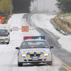 Constable Ritchie Ellwood, of Dunedin, guards the entrance to Three Mile Hill Rd following its...