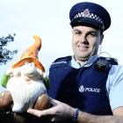 Constable Tim Coudret, of Mosgiel,  holds one of many garden ornaments found at a Mosgiel...