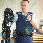 Constable Tom Taylor, of Balclutha, holds the VCR tape and fishing line that was strung across a...