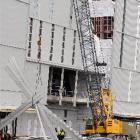 Construction workers remove large lengths of iron cladding from the Leith after strong winds blew...