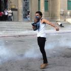 Coptic Christians cover their faces after tear gas was fired by police during clashes with...